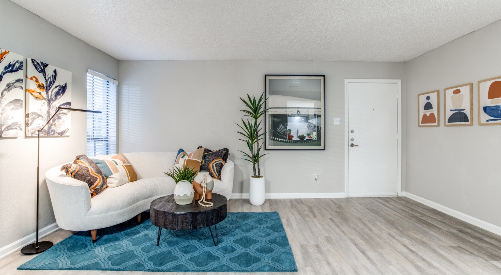 a living room with a blue rug and white furniture at The  Booker