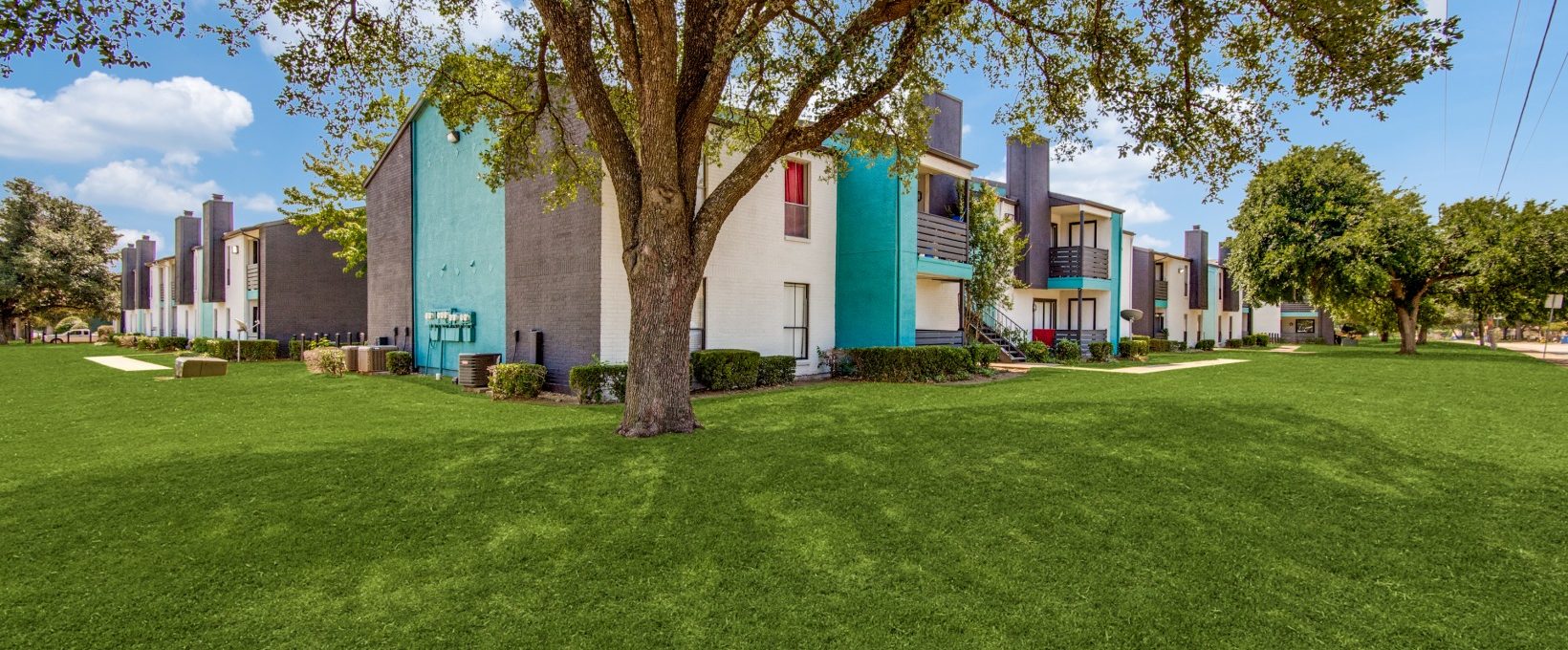 the exterior of a building with grass and trees at The  Booker