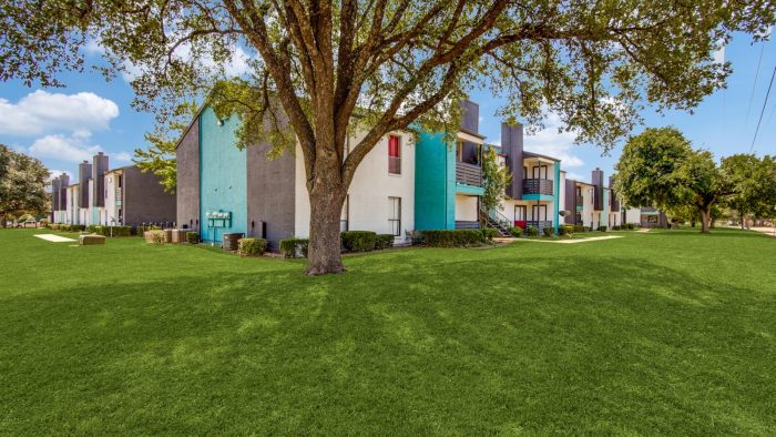 the exterior of a building with grass and trees at The  Booker