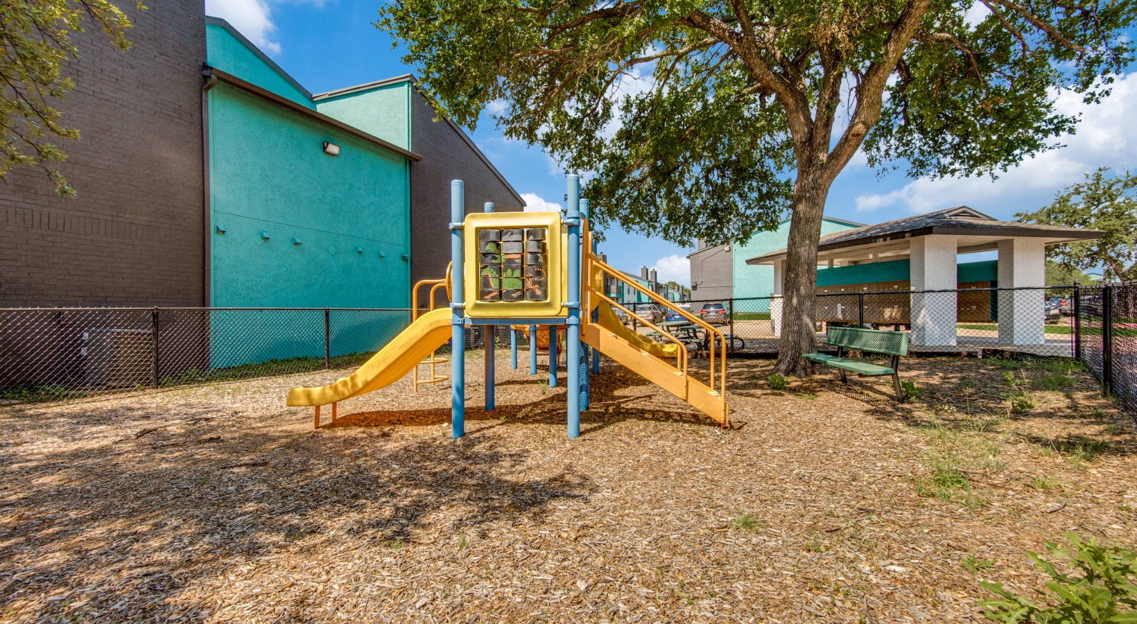 a playground with a blue and yellow building in the background at The  Booker
