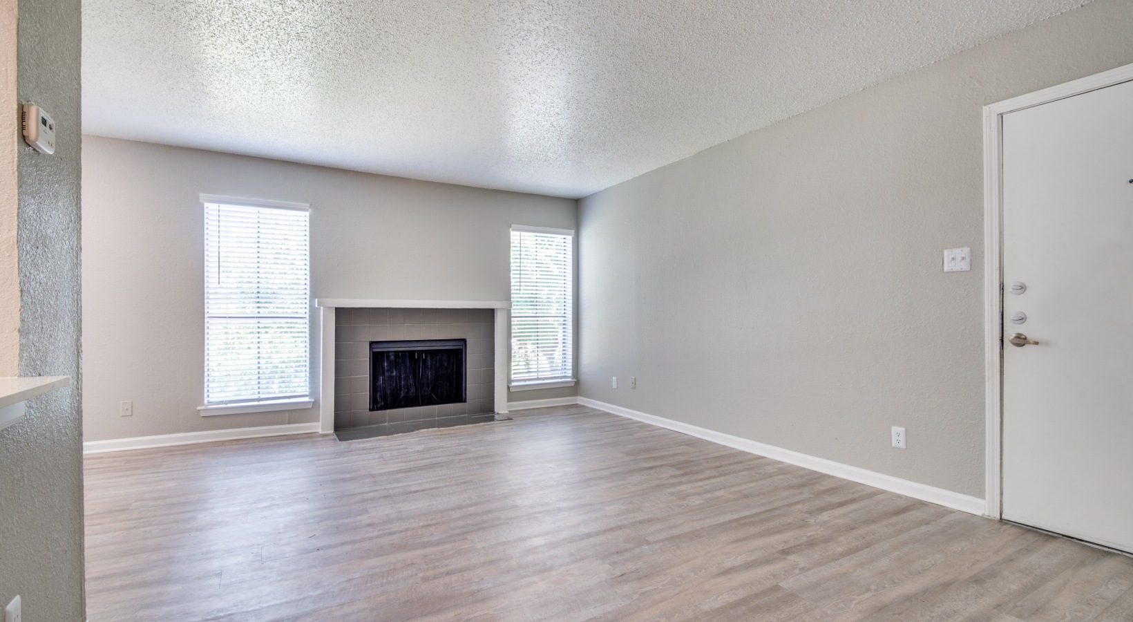 empty living room with fireplace and hardwood floors at The  Booker